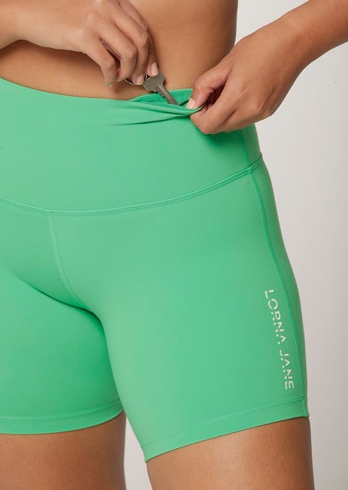 model showing the hidden key pocket in a pair of Lotus No Chafe Bike Shorts in Mojito colour