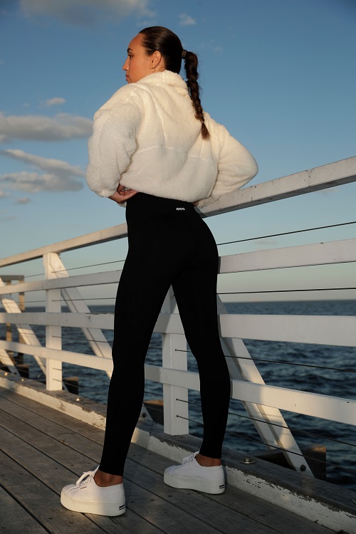 brunette woman wearing black fleece lined leggings and a cream colored sweater