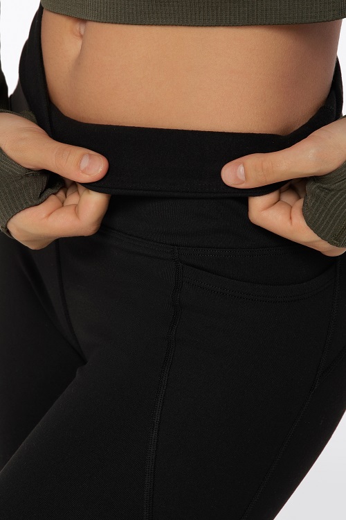 Model folding waistband of leggings down to show fleece lining