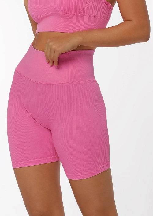 Back image of a woman wearing matching bike shorts and sports bra in washed milkshake colour